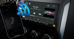 A cellphone with bluetooth bars coming out of it going towards a car audio radio screen